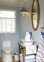 Toalettrommet har fått sin kjølige blåfarge fra himmelen, og innslag av gyllent treverk gjør rommet lunt og hyggelig. 