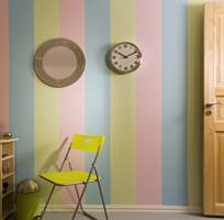 Den stripete veggen er perfekt bakteppe for en limegrønn klappstol, et speil med glitterramme og en veggklokke.