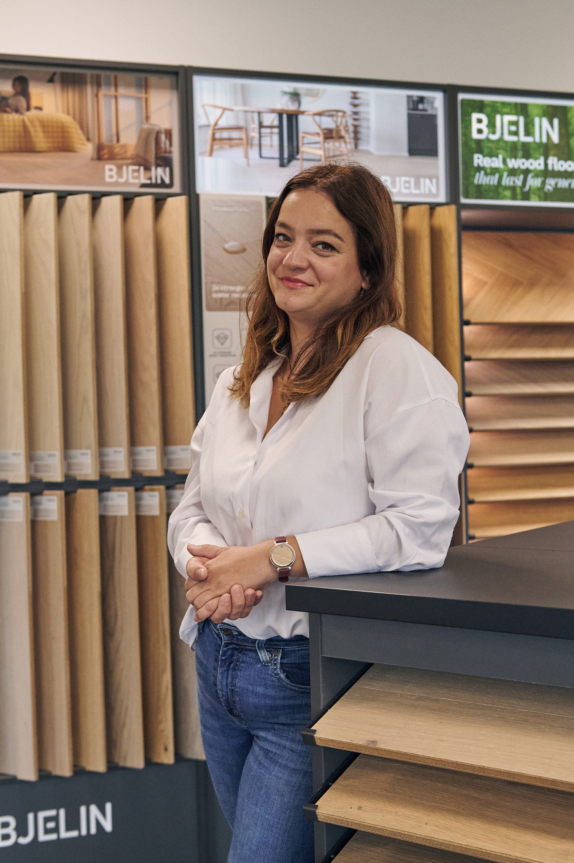 Dame i hvit bluse i gulvshowrom med store prøver