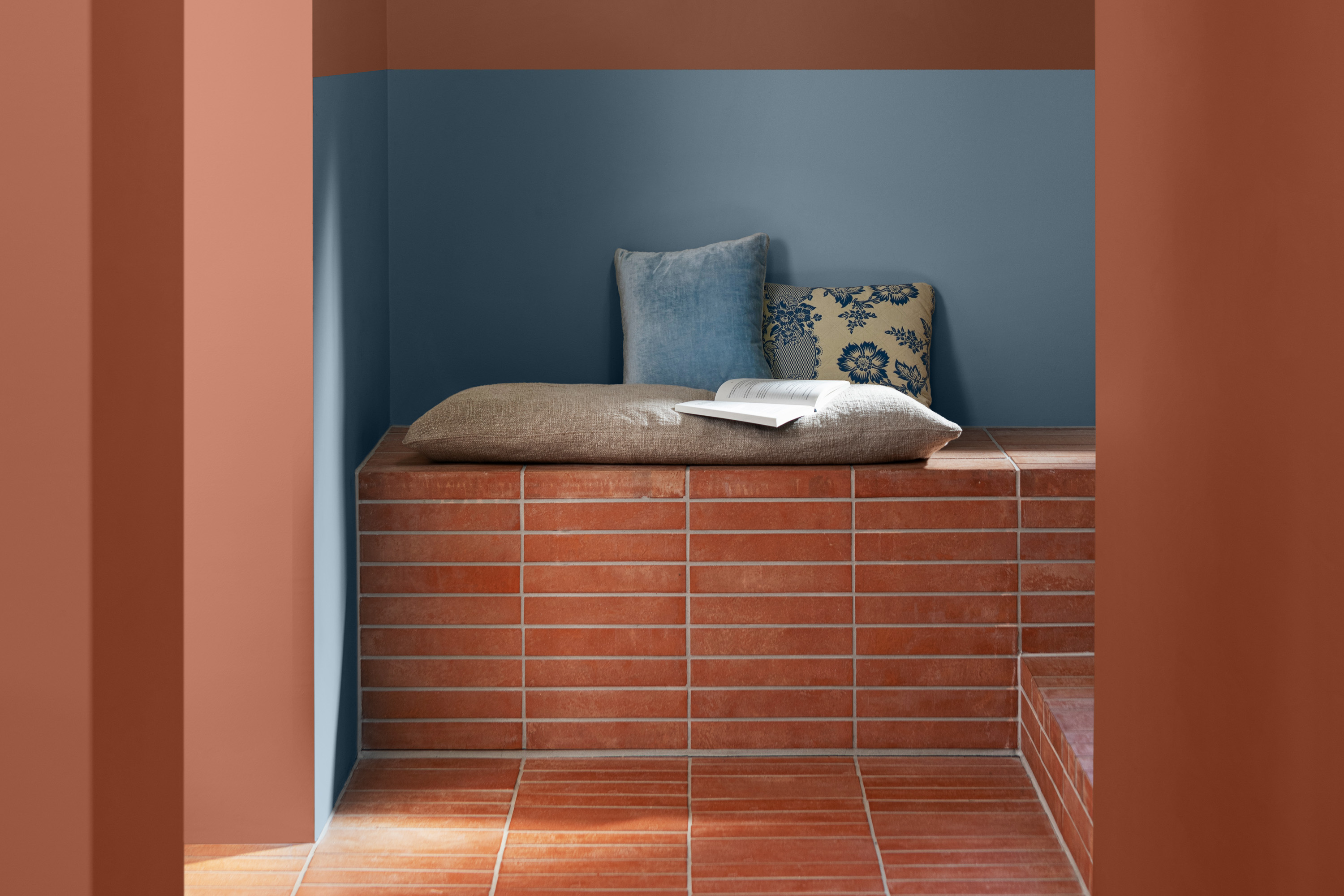 Terracottafarget vegg og gulv med blått felt på veggen