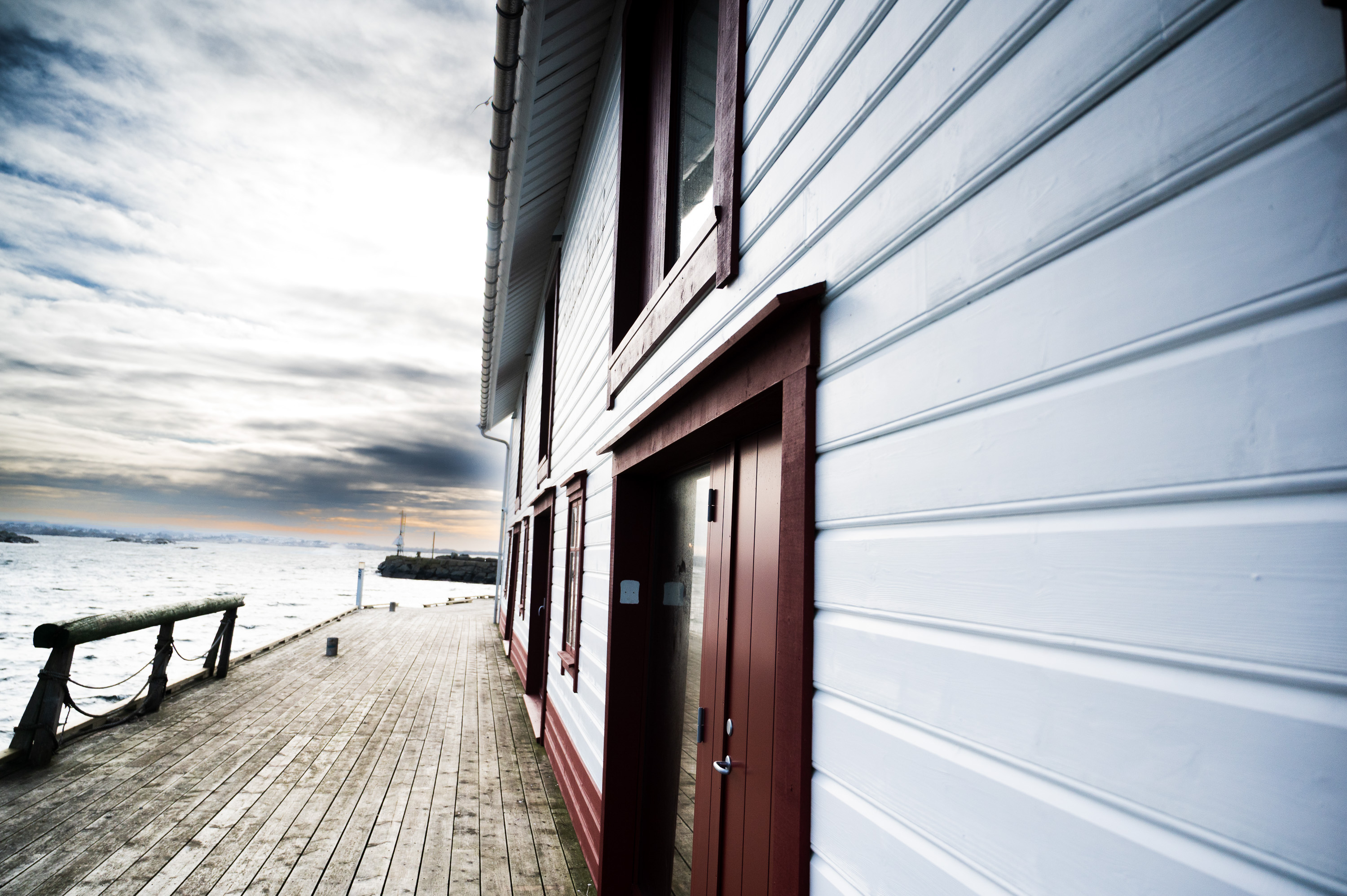 hvitmalt fasade med liggende kledning, røde detaljer 