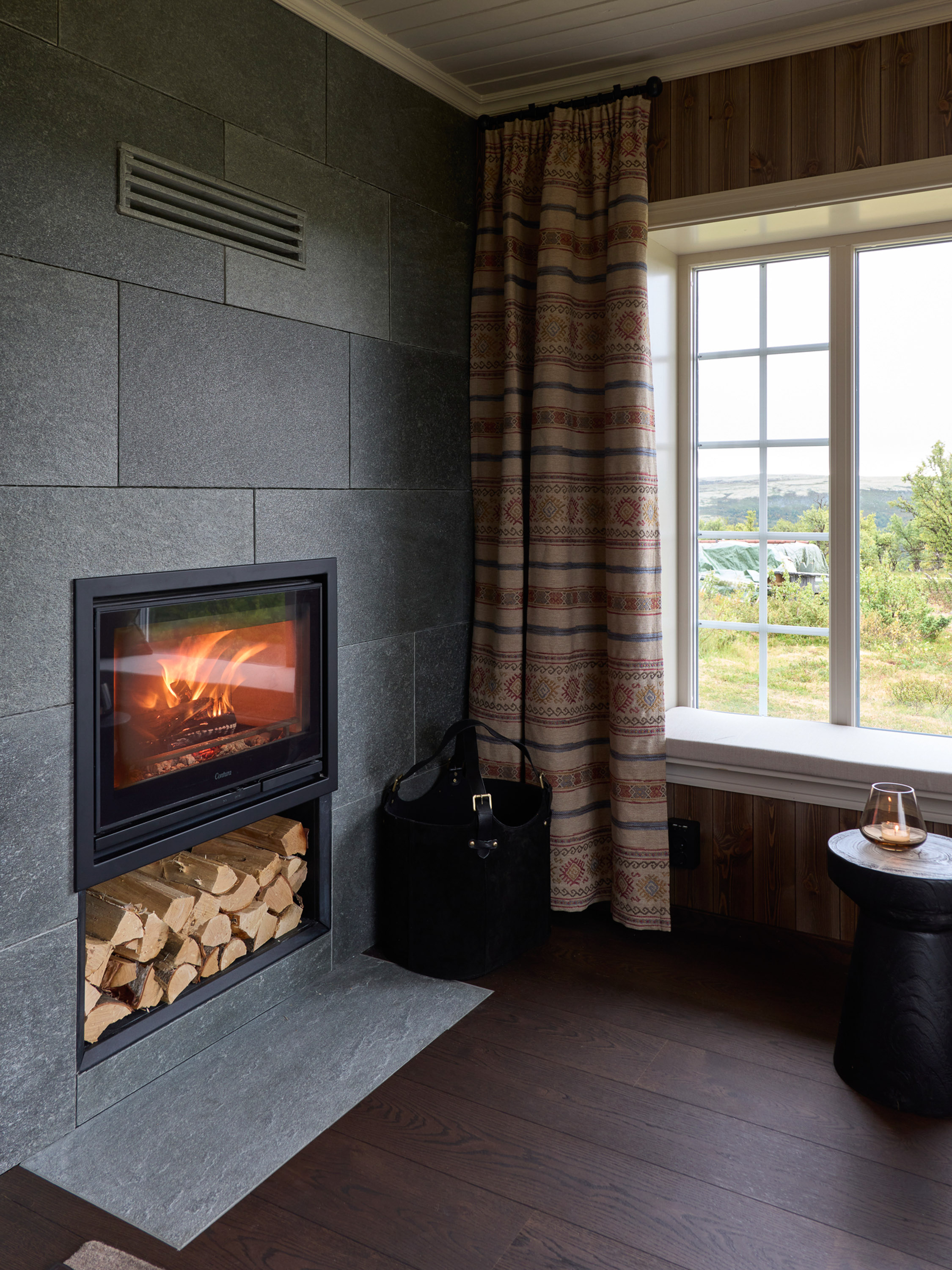 hytte med mørkt gulv og rustikk gardin 