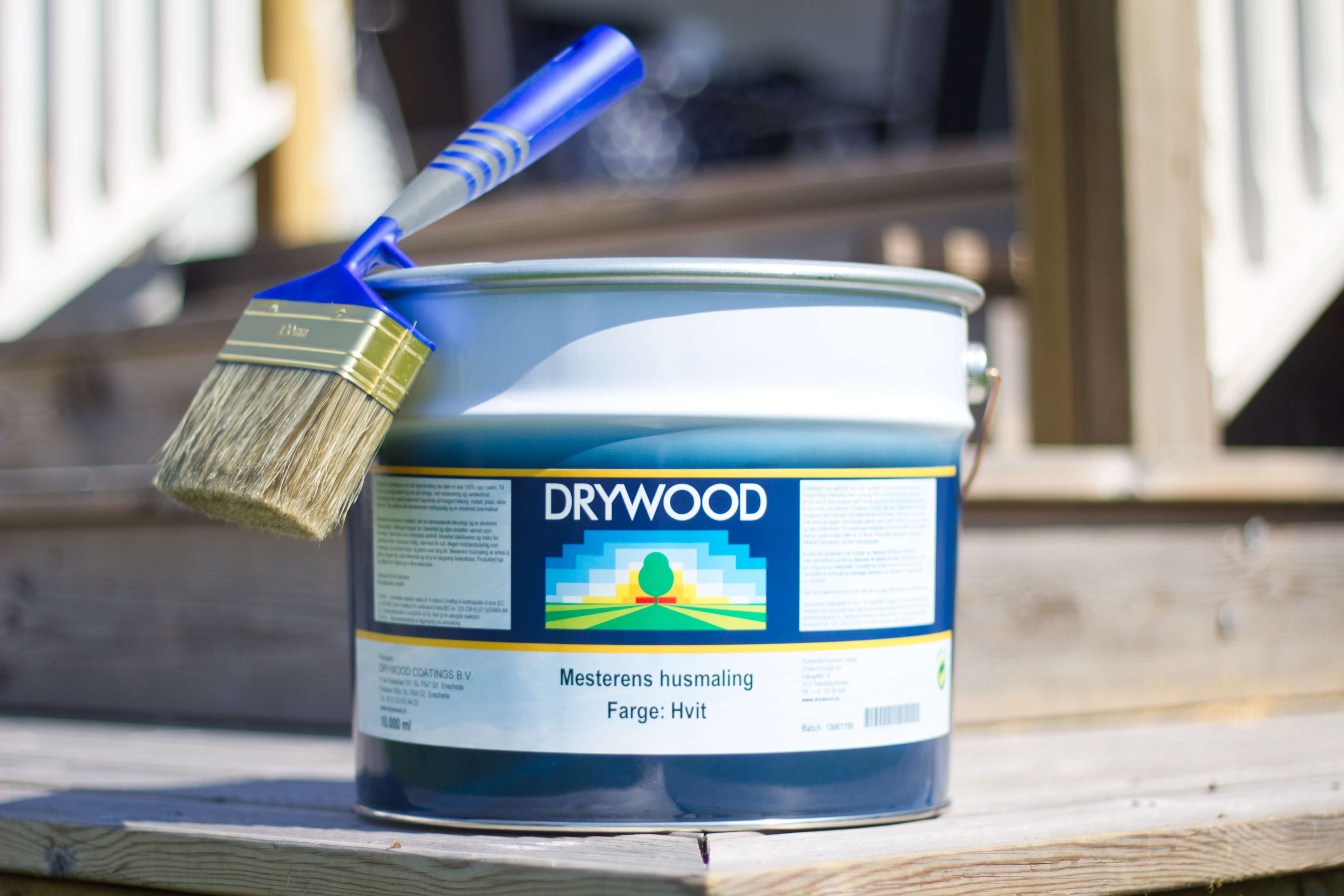 Spann med maling og en pensel på lokket. Mesternes husmaling