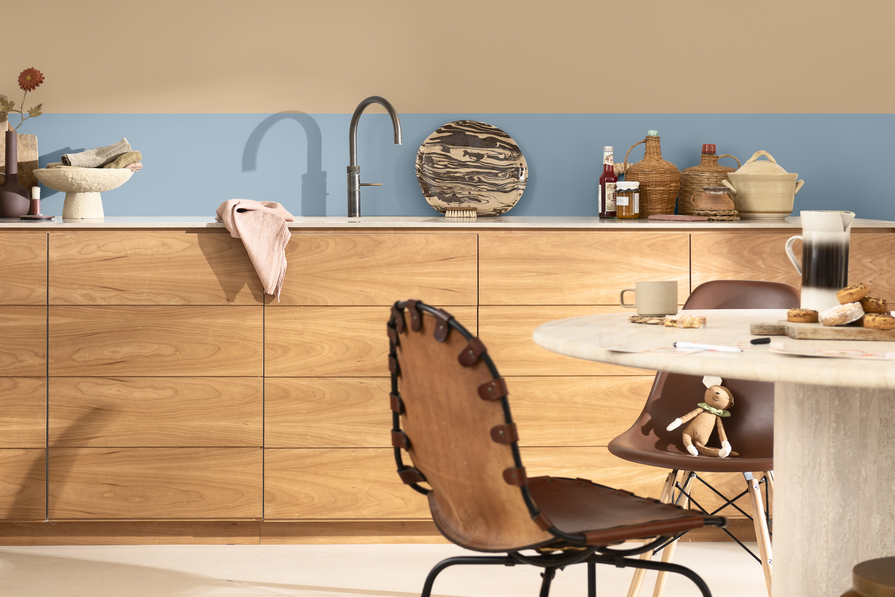 kjøkken med tredører, sandbeige vegg med blå bred stripe