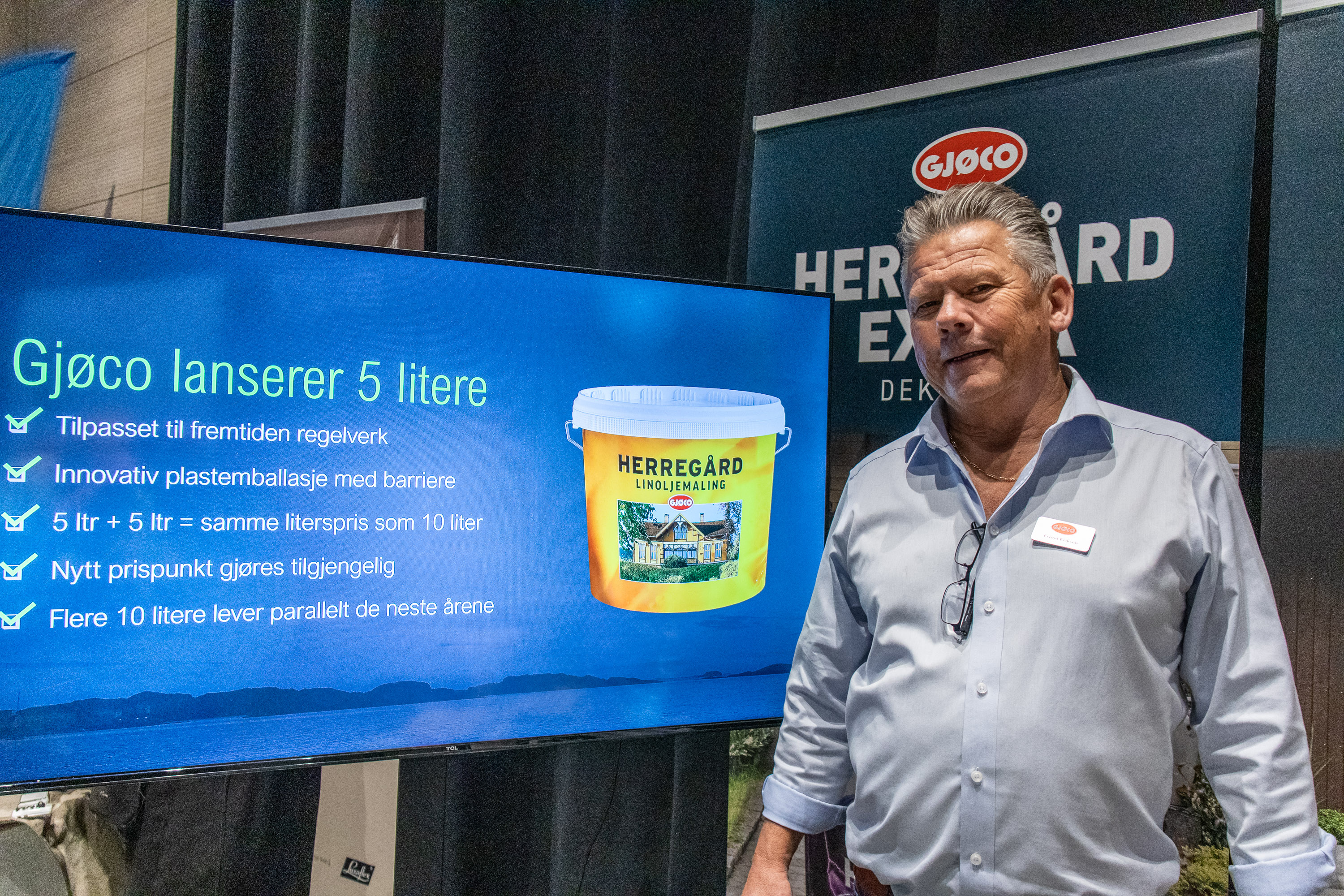 mann foran stor skjerm med bilde av malingspann