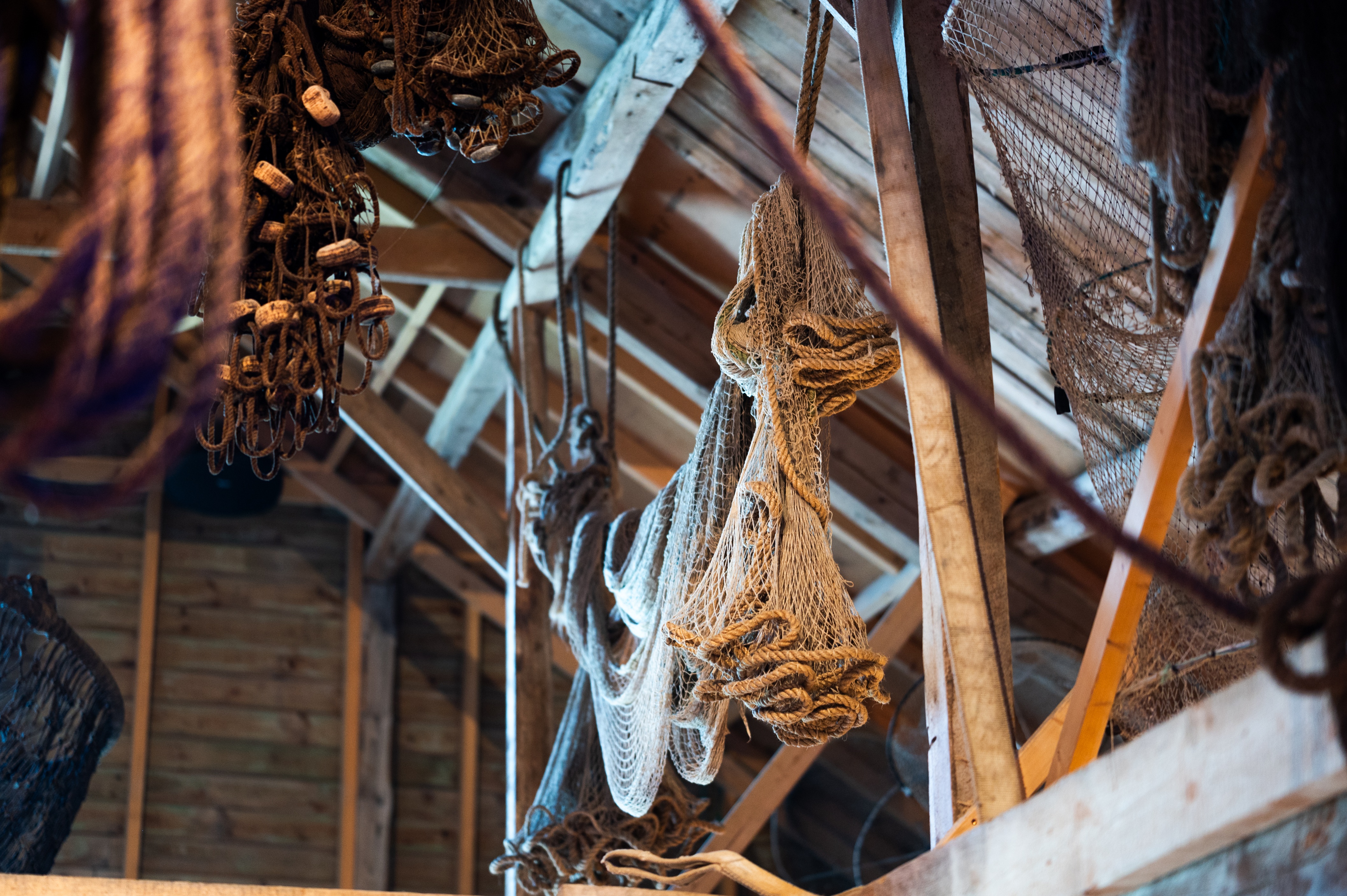 gamle fiskeredskaper henger fra gamle trebjelker 