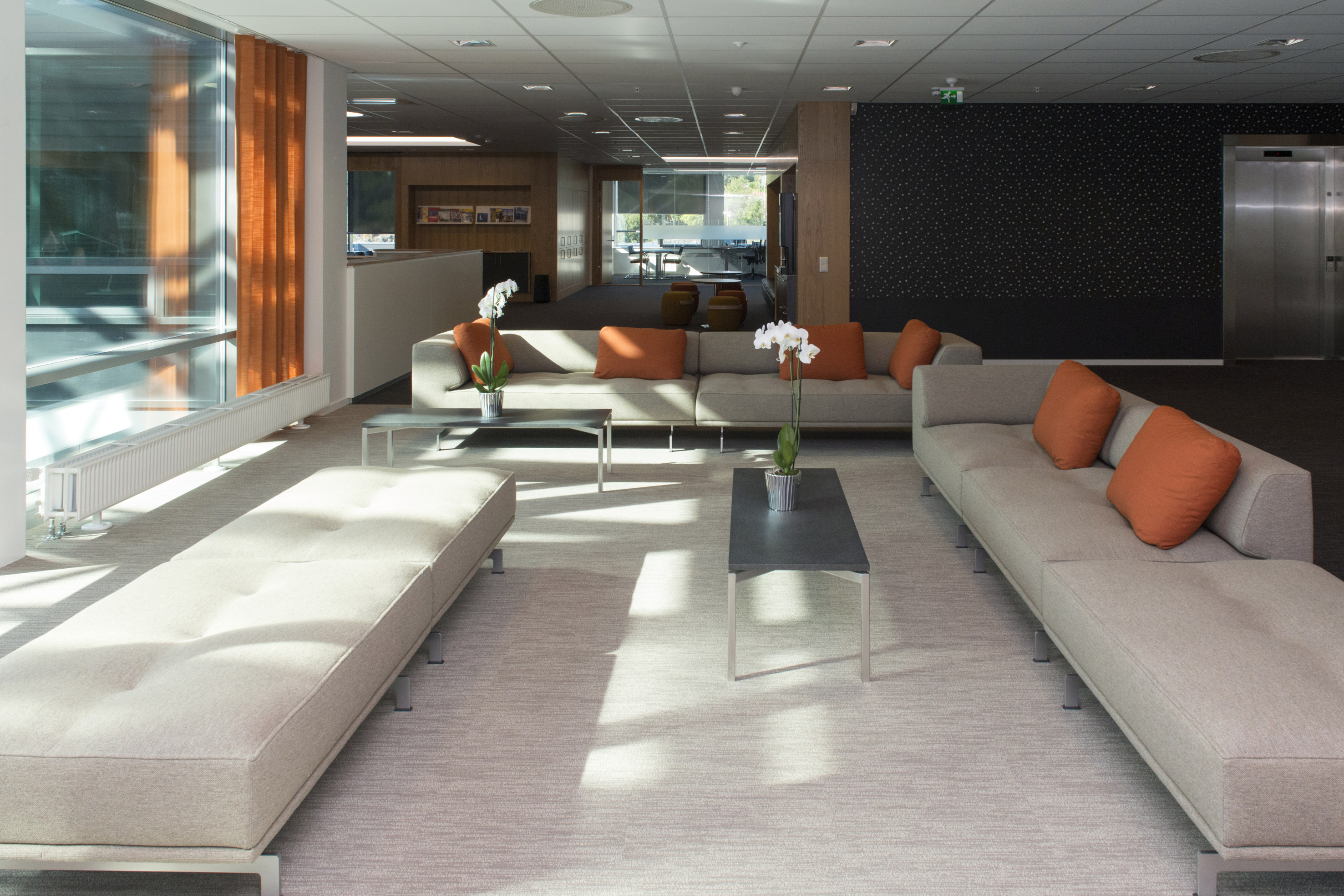 MARKØR: Den sosiale sonen i 3. etasje i kontorbygget er markert med teppefliser i en lysere kulør, og det er tilført elementer i rust og oransje på detaljer.