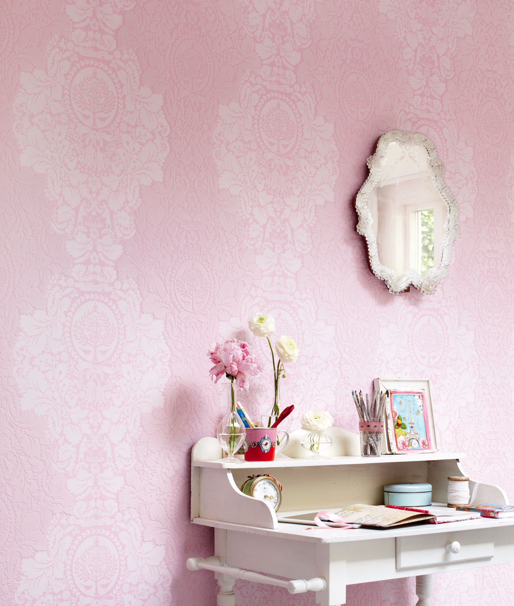 Her fremhever interiørgjenstandene det søte i det rosa tapetet.