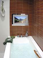 Nå kan du drømme deg bort i badekaret med stearinlys, badeskum og en god film. Nye TV'er åpner mulighetene for baderomsunderholdning.