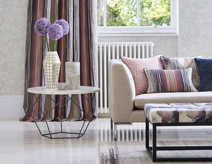 Puter, pledd, gardiner, gulvtepper og tapet gjør stua mer behagelig før øyne og ører. Tekstiler fra Tapethuset.