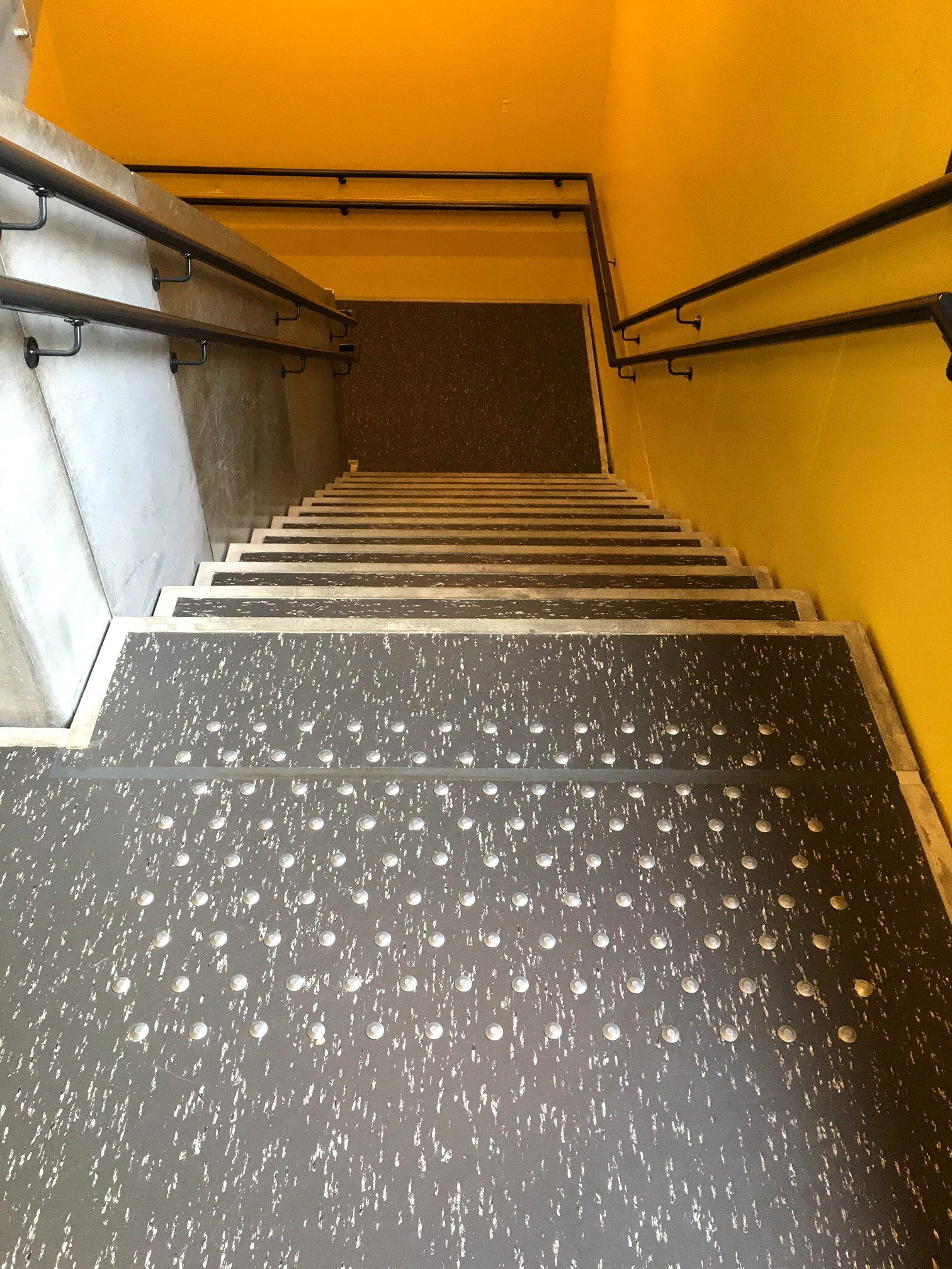 LIKE TRAPPELØP: Alle bi-trappene har gule vegger, og linoleum i mørkegrått med hvite spetter. Belegget er ikke lagt helt ut på avsats og trappetrinn, slik at betongen skaper en tøff ramme. 