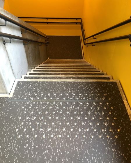 LIKE TRAPPELØP: Alle bi-trappene har gule vegger, og linoleum i mørkegrått med hvite spetter. Belegget er ikke lagt helt ut på avsats og trappetrinn, slik at betongen skaper en tøff ramme. 