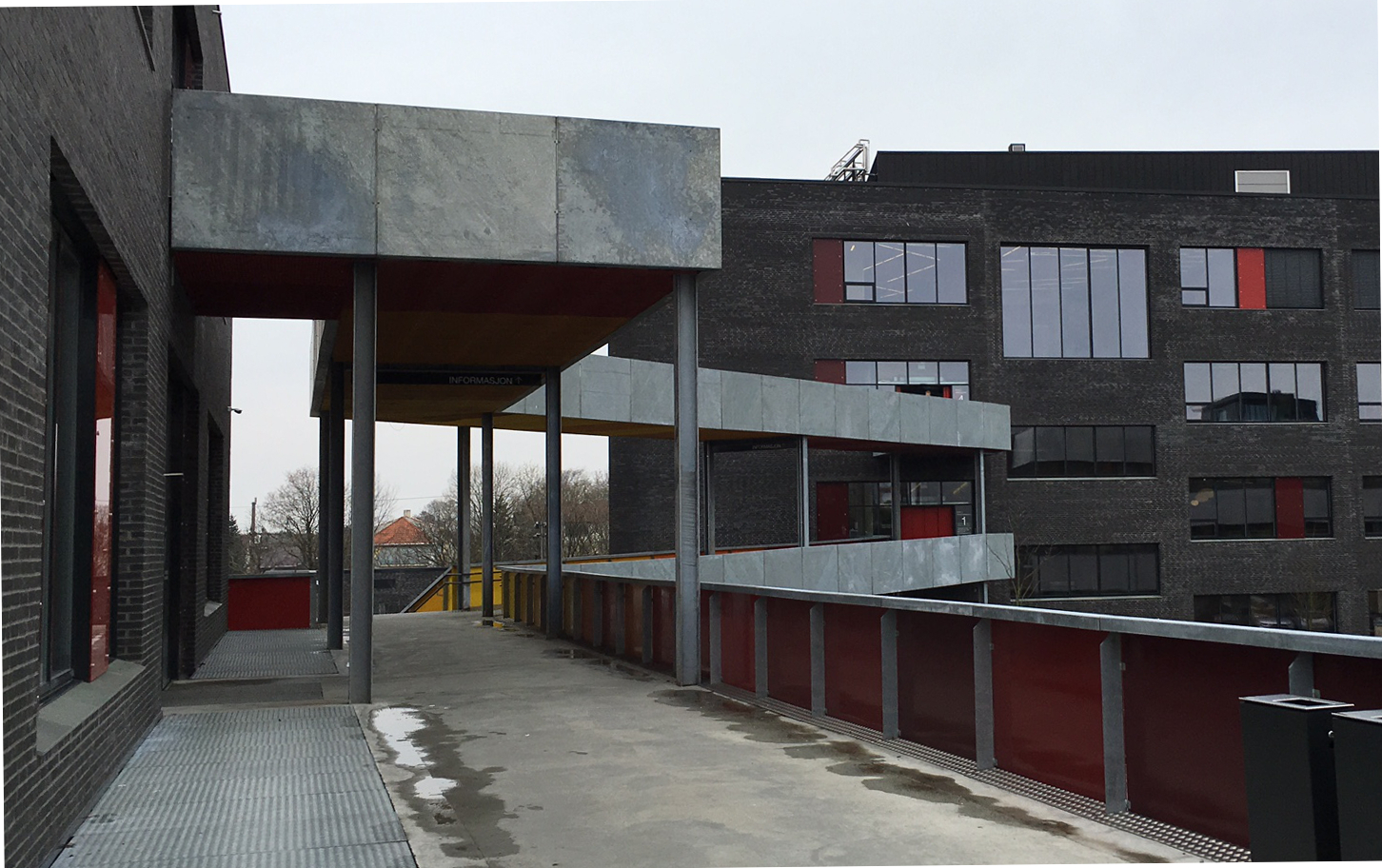 TØFF FASADE: Bygningene har fasade av mørk tegl, som gir et barskt uttrykk. Røde og hvite plater er friske fargeinnslag som bryter med det mørke. 