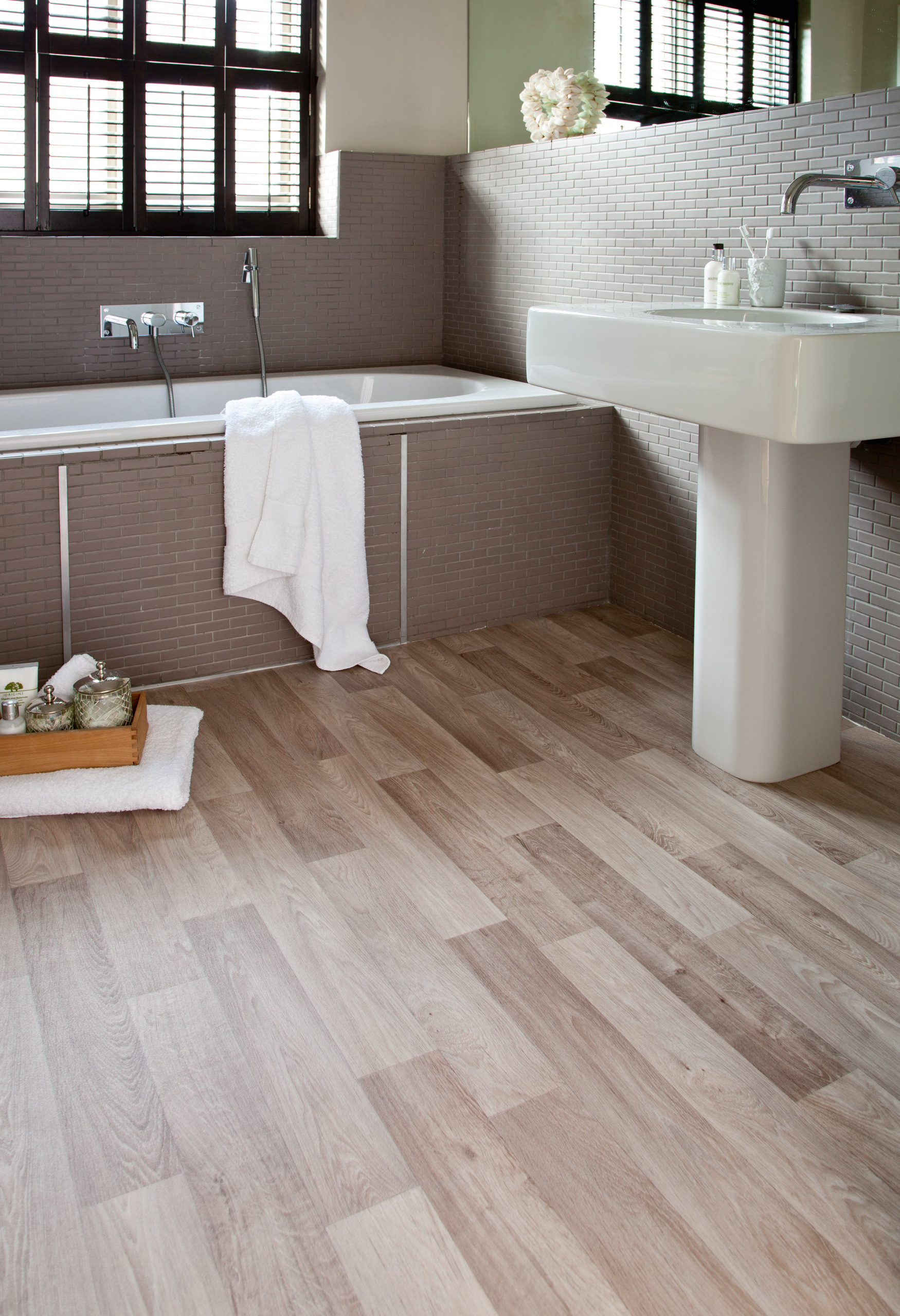 Det er ingen lov som sier at et vinylbelegg p&aring; bad m&aring; v&aelig;re beige eller lysegr&aring;tt. Her er det parkettlook p&aring; badet.