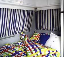 Sofabenk og bord forvandles med enkle grep til en dobbeltseng. Med fargerikt sengetøy blir det et riktig innbydende soverom.