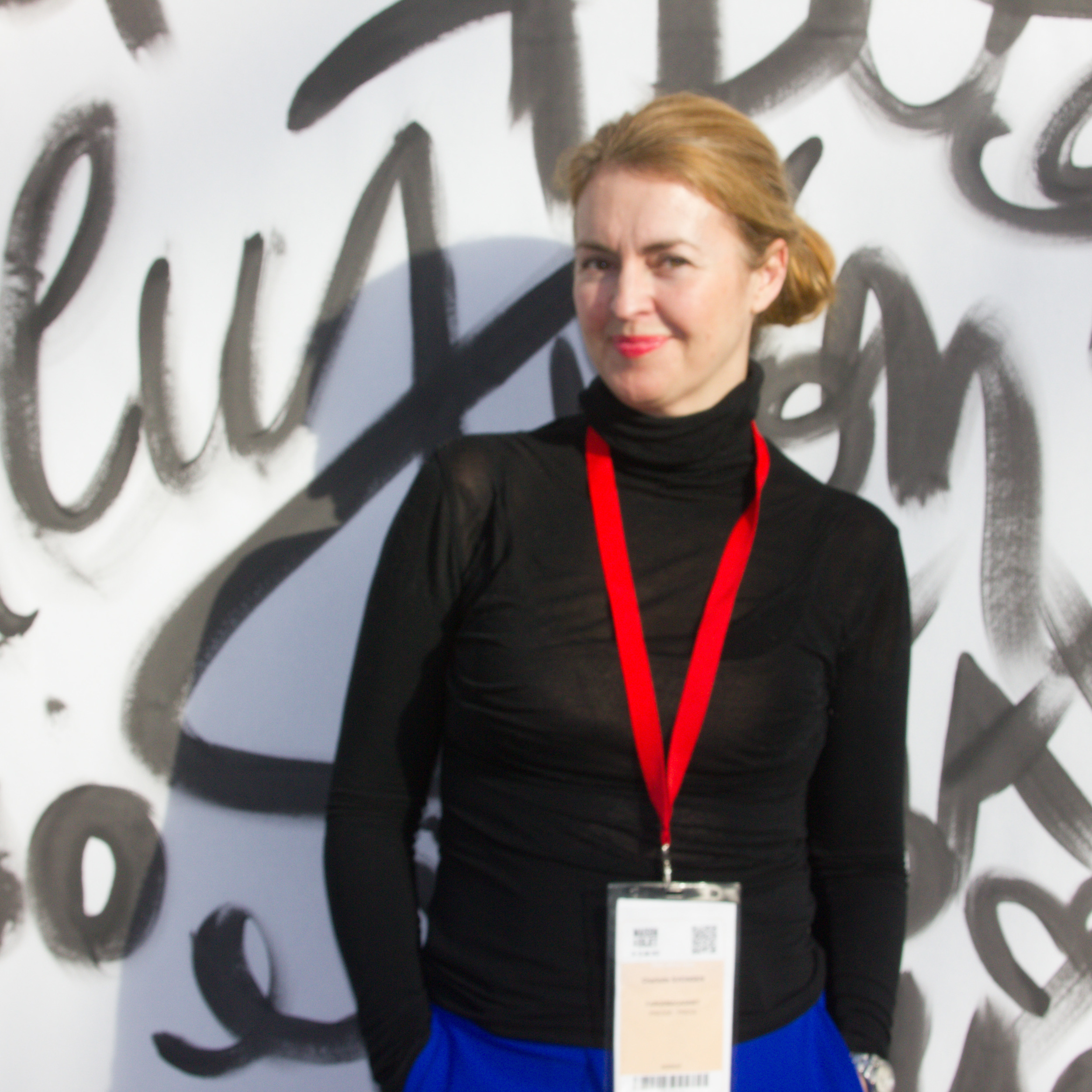 dame svarthvit bakgrunn blå bukse svart genser rødt