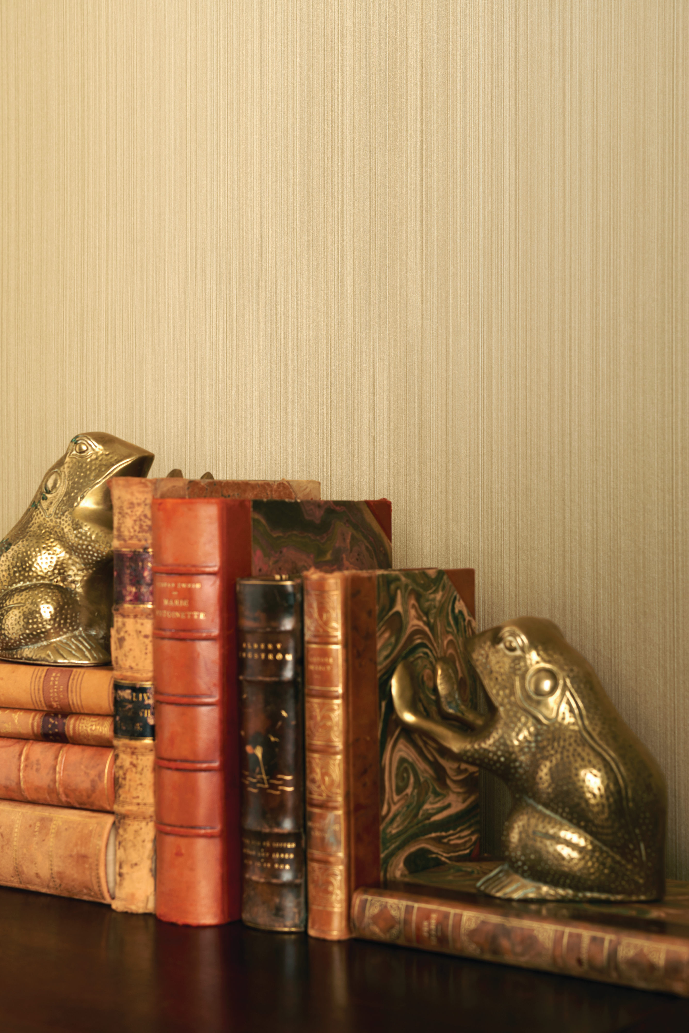 Gyllent lær, tapet med tekstur i varm farge og gyllent metall er en lun miks for «my home is my castle».