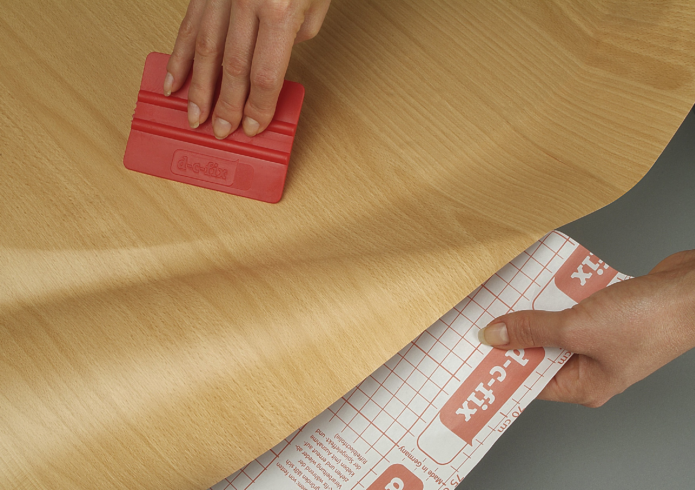 Stryk ut luftbobler, og jevn ut med en tapetglatter eller en klut. 