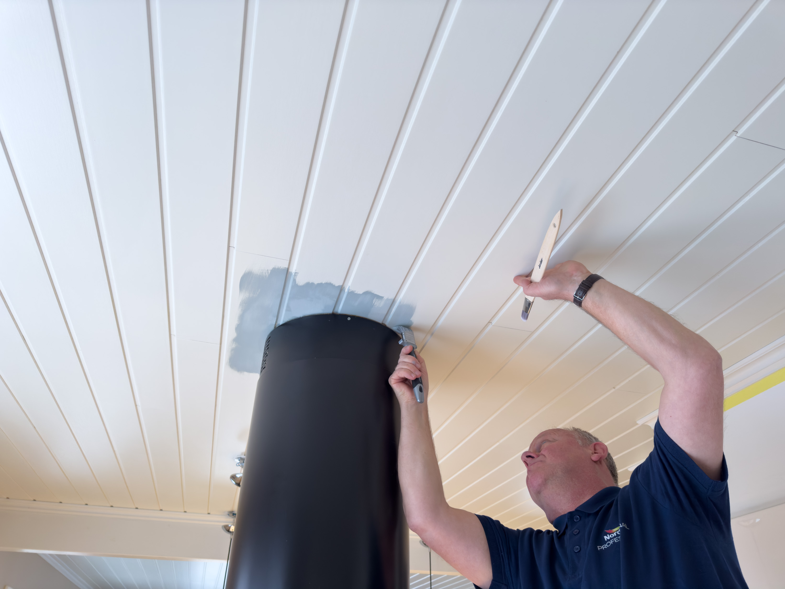 Per Myhre sparer ut rundt kjøkkenventilatoren i taket.