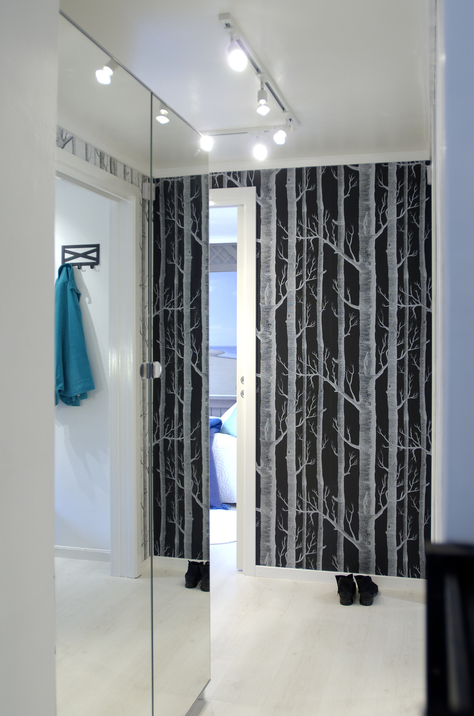 Gangen er en forlengelse av entréen, og har tregulv og sorthvite tapeter. 