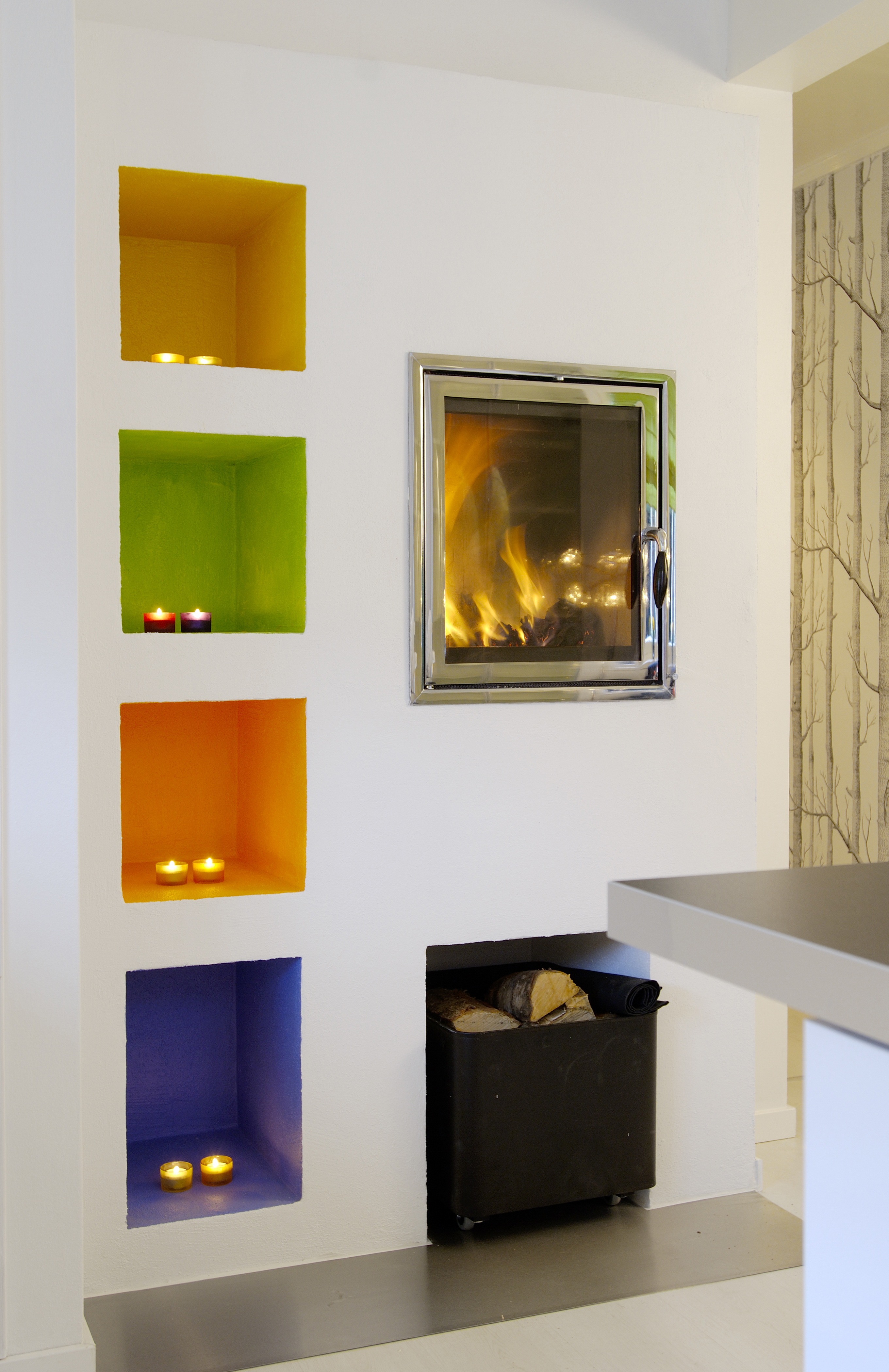 Fire nisjer i knallfarger. Når lysene tennes, reflekteres fargene og tilfører rommet spennende lys. 