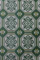 Et teppe med mønster i fine grønn- og gultoner.