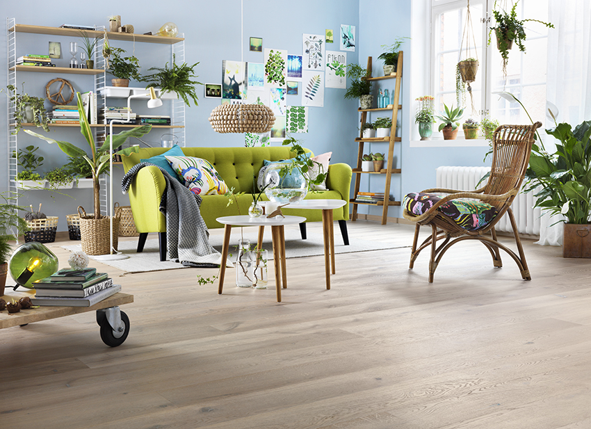 LENES FAVORITT: Av tregulv er det eikeparketten My Heritage fra Tarkett. Her er den i fint samspill med lyseblå vegger, grønn sofa. Og prikken over i-en er en bitteliten dasj knall rosa. (Foto: Tarkett)