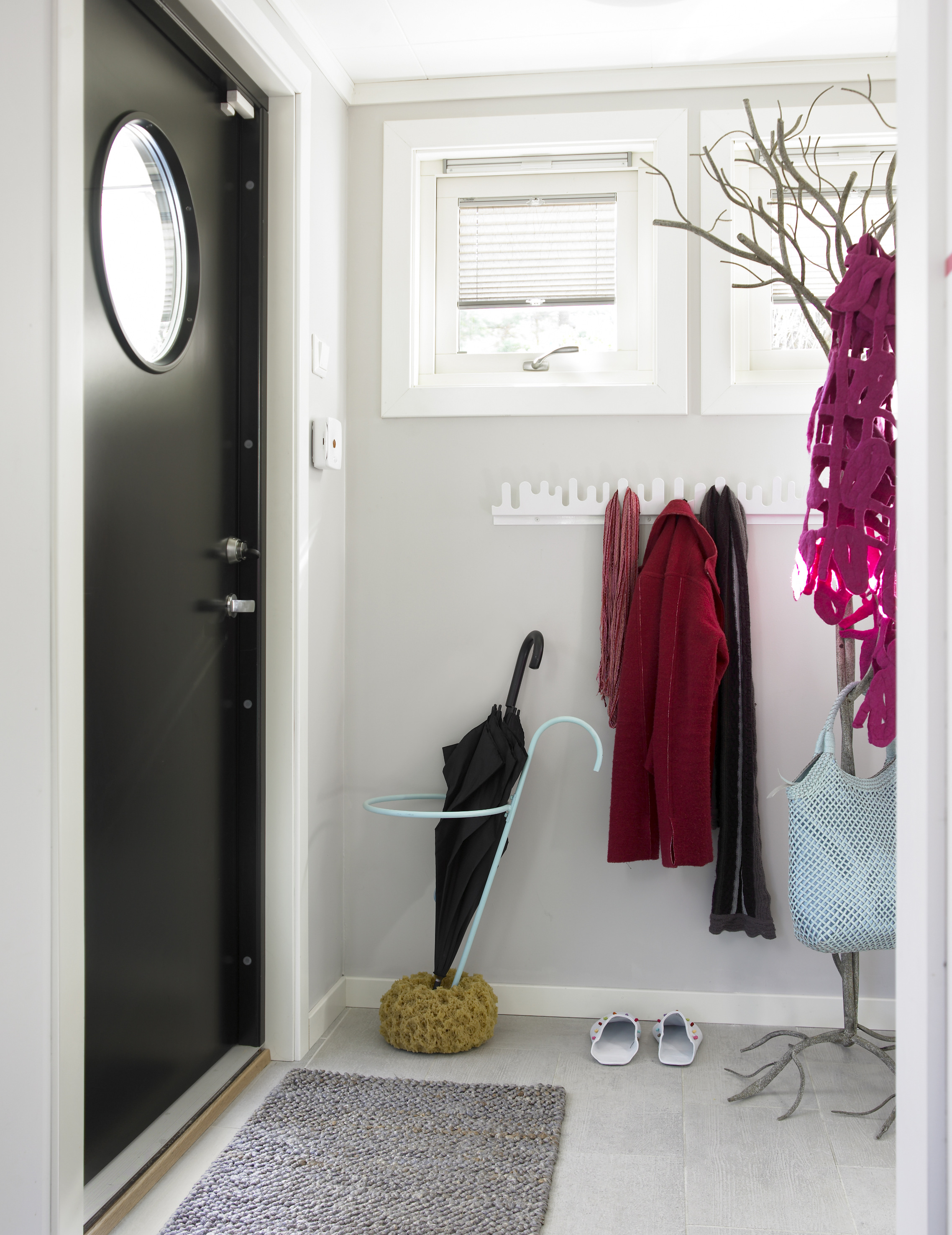 Døren med det runde vinduet er blitt et flott blikkfang, pusset opp i en nestensort farge. 