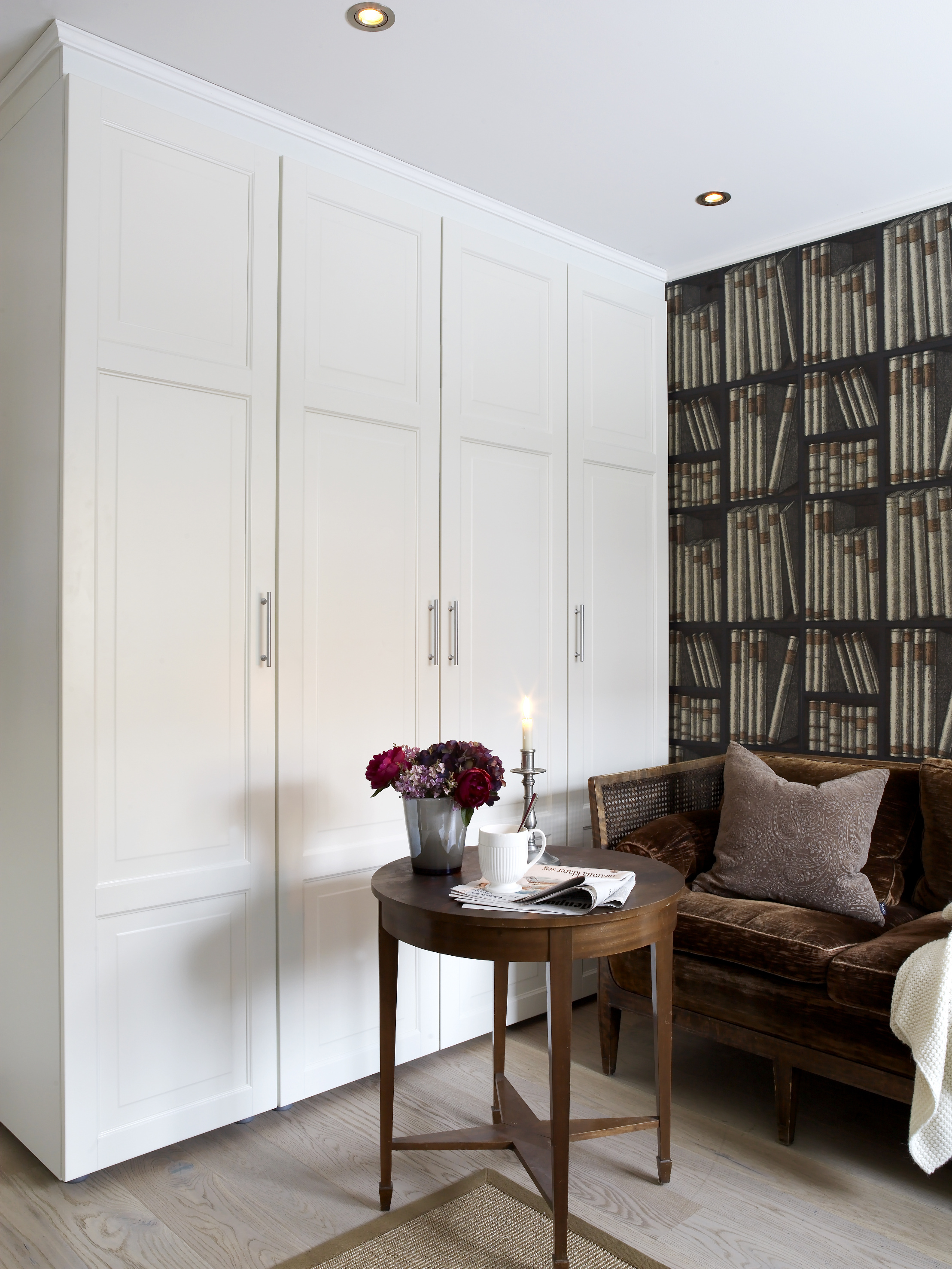 Tapetet, den gamle sofaen og bordet i fin kontrast til de stramme skapene – et hyggelig hjørne. 