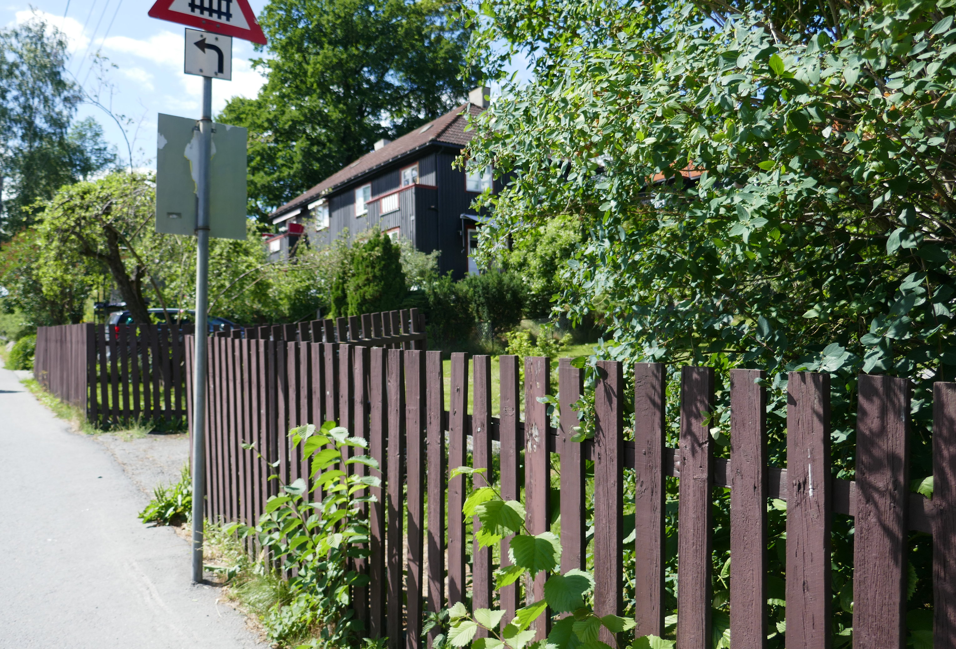 Mørkt gjerde rundt huset