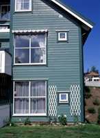 For å skjule deler av huset, kan du velge to farger som glir over i hverandre. Her er overgangen mellom vindu og vegg myk: grønn hovedfarge med mørkere grønne vinduer. Det hvite, derimot, gir en markant overgang.
