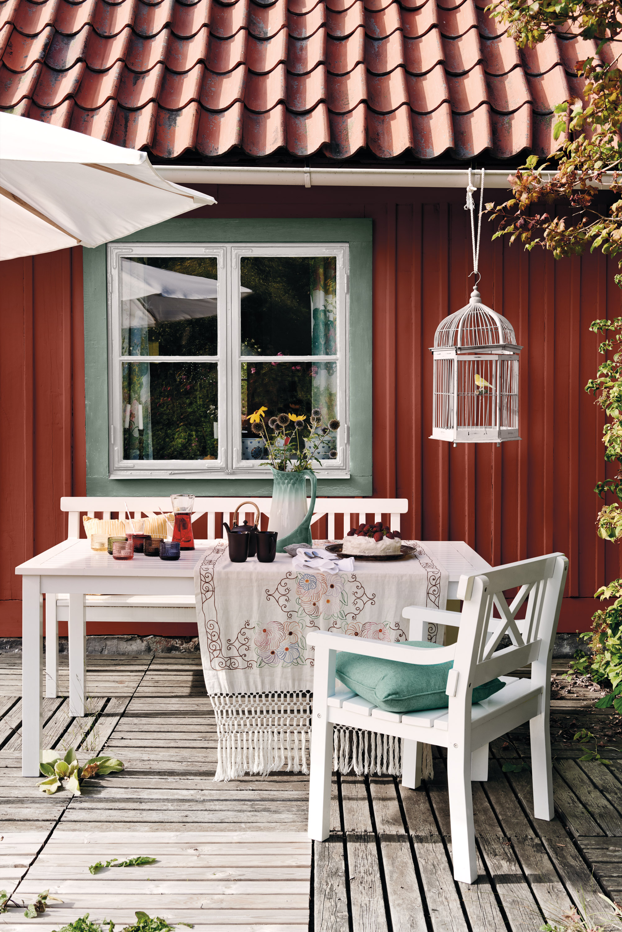 Utemøbler på terrasse mot rød fasade