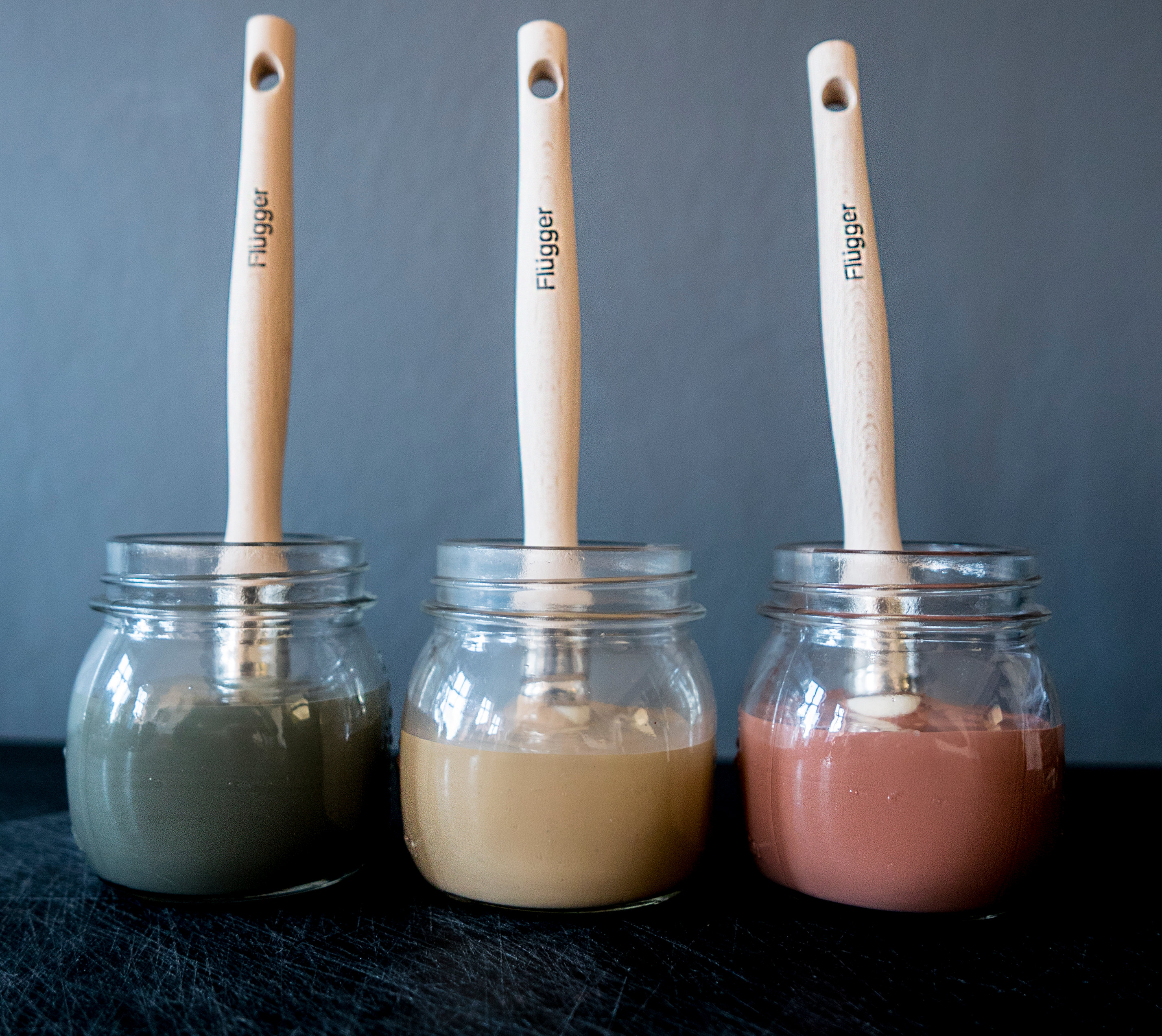 tre glass med pensler nedi, ulike farger 