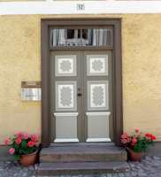 Klassisk dekorativ dør på et eldre murhus. Det er brukt fire forskjellige farger på dørpartiet, men fargene matcher.