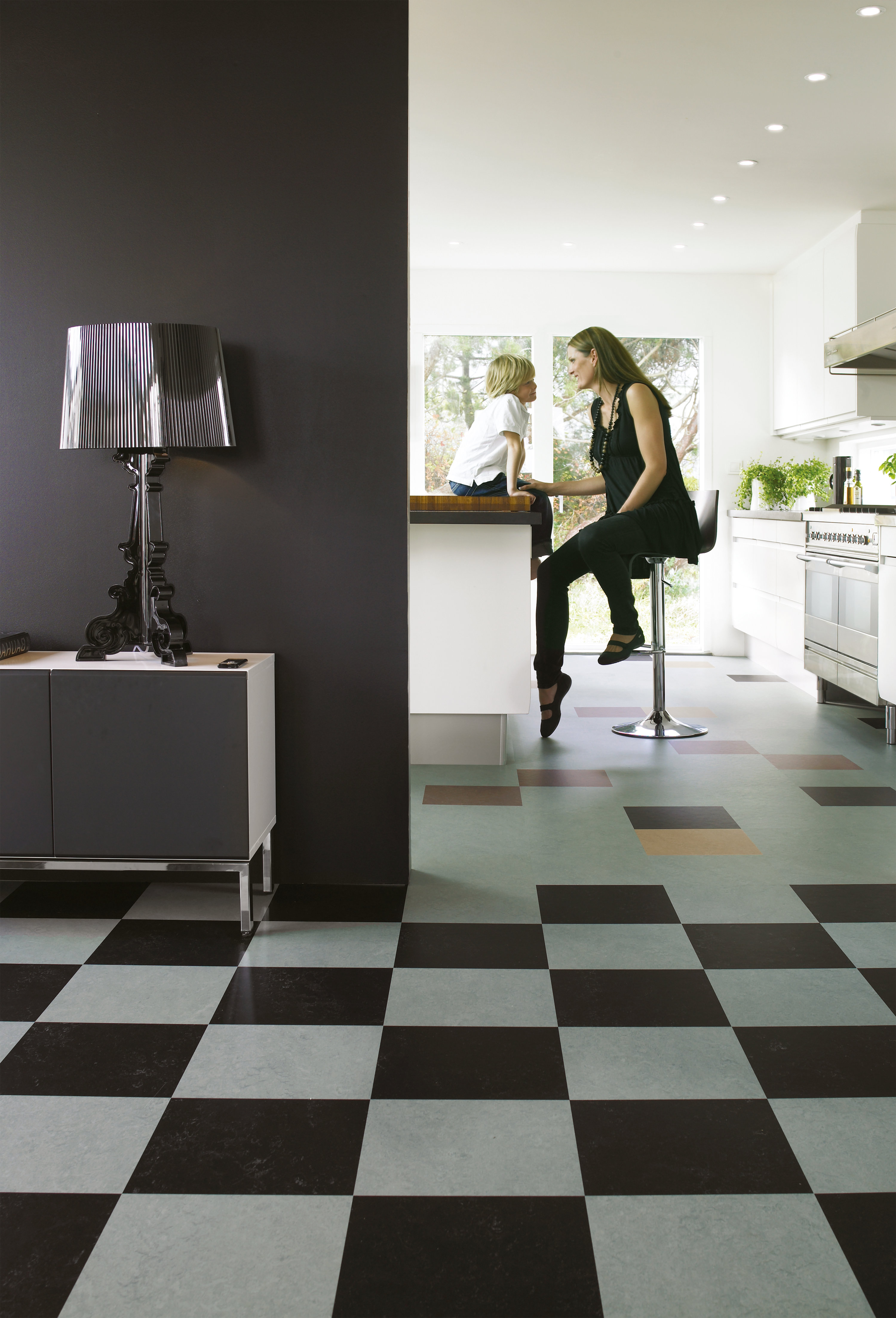 Sjakkruter i sort/hvitt Marmolem klikkfliser. Tydelig mønster og sterke kontraster. Inntrykket roes når den mørke fargen gjentas på veggen i tilstøtende rom. 