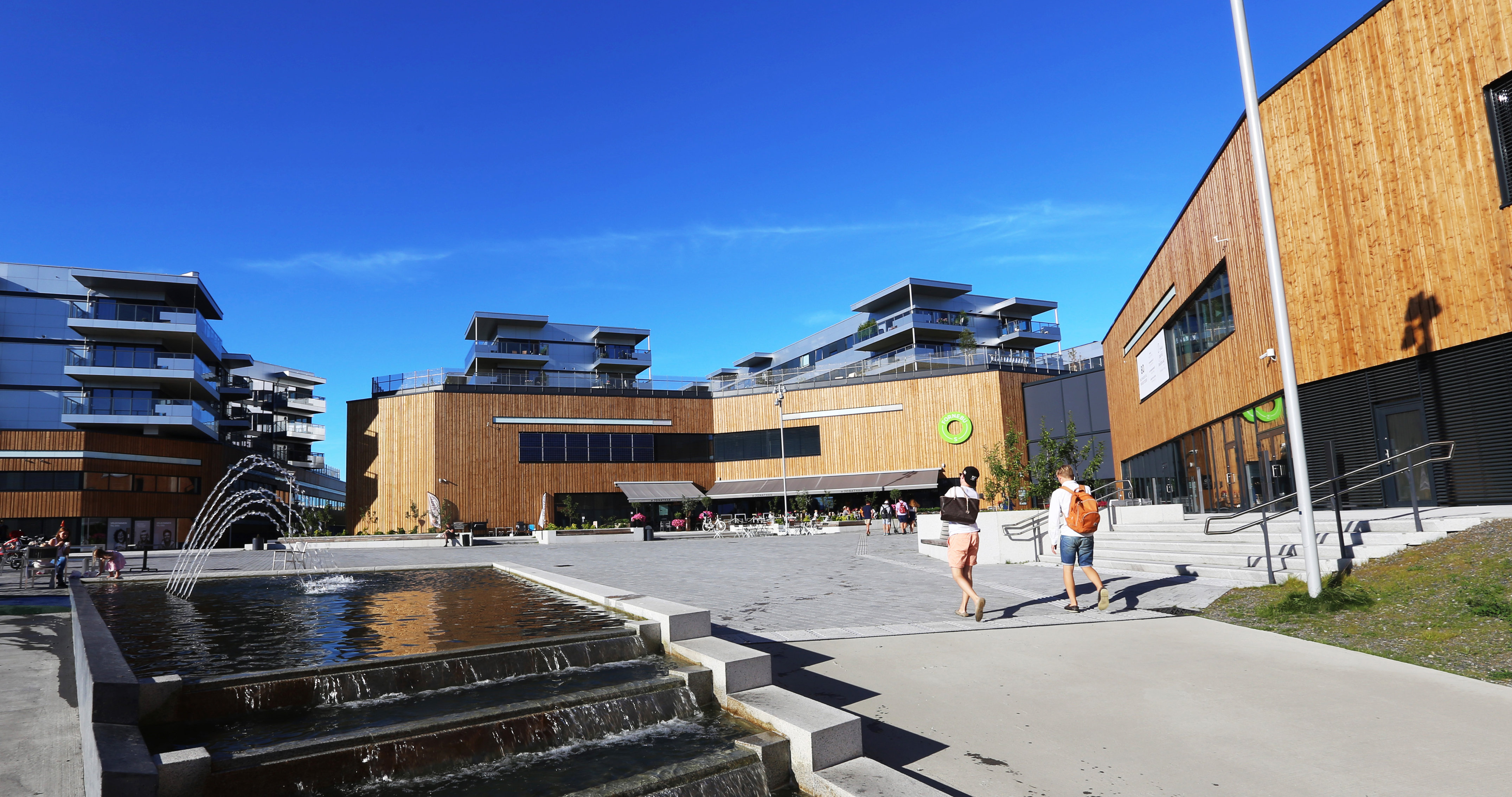 Birgitte Skjerve tror vi vil se mye tre i arkitekturen fremover. På Fornebu S er det valgt stående trekledning i beiset gran på fasaden. Bygget er tegnet av AMB Arkitekter AS. Foto: AMB Arkitekter AS