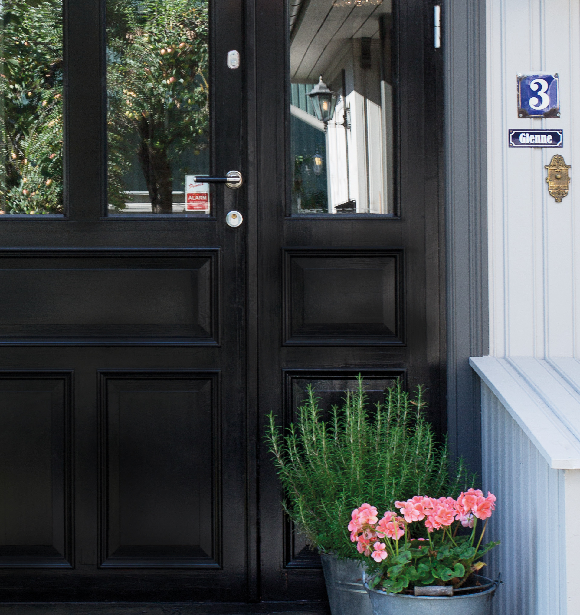 NESTEN SORT D&oslash;ren er s&aring; m&oslash;rk (970 M&oslash;rk Brun) at den ser sort ut, men er ikke like hard som sort kan v&aelig;re. Gr&aring; omrammimg (954 Aske/S 7502-Y) gir myk overgang til fasadefargen. (Foto: Butinox Futura)