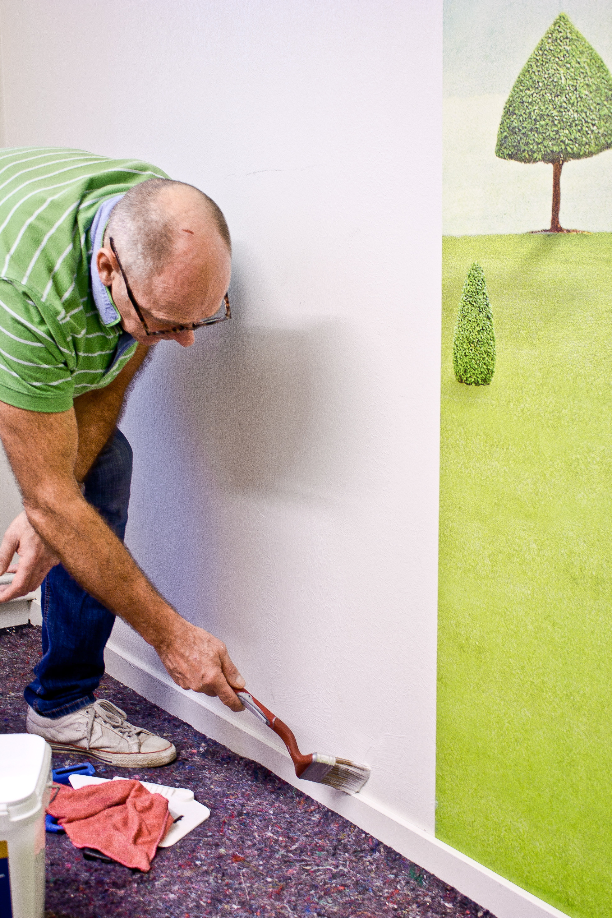 Bruk en langskaftet malepensel for å komme til med limet langs listene.