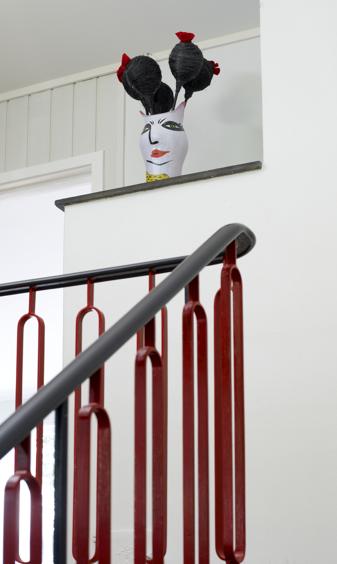 En vase samler fargene i trappen, og dens mykere former bryter fint med alle de rette linjene i rommet. 