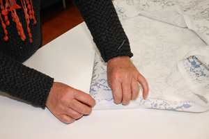 For at gardinen skal henge pent sys først dobbelt fald nede, og deretter lages dobbel sidefald. Jarekanten må klippes vekk.