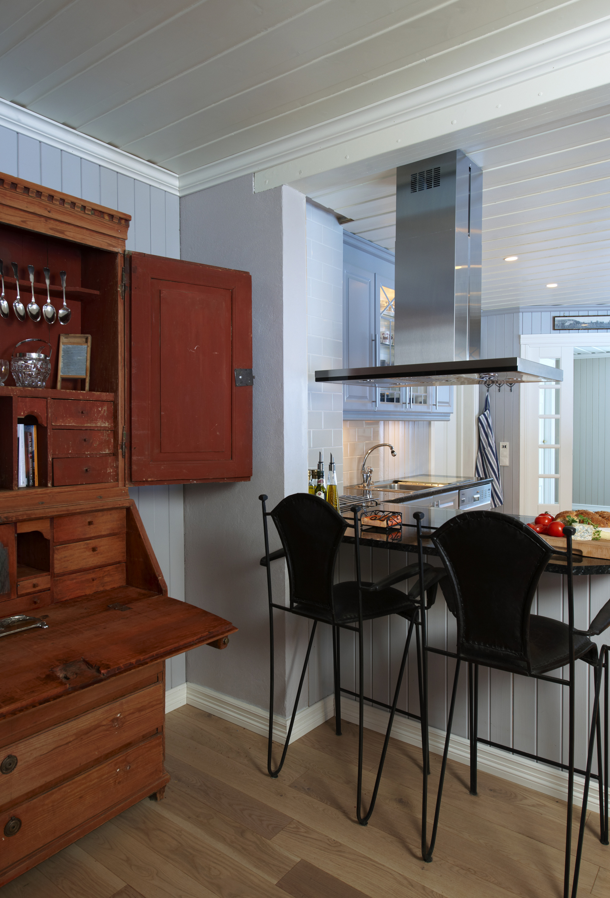 Spennende møte mellom et gammelt skap og moderne stoler og innredning. 