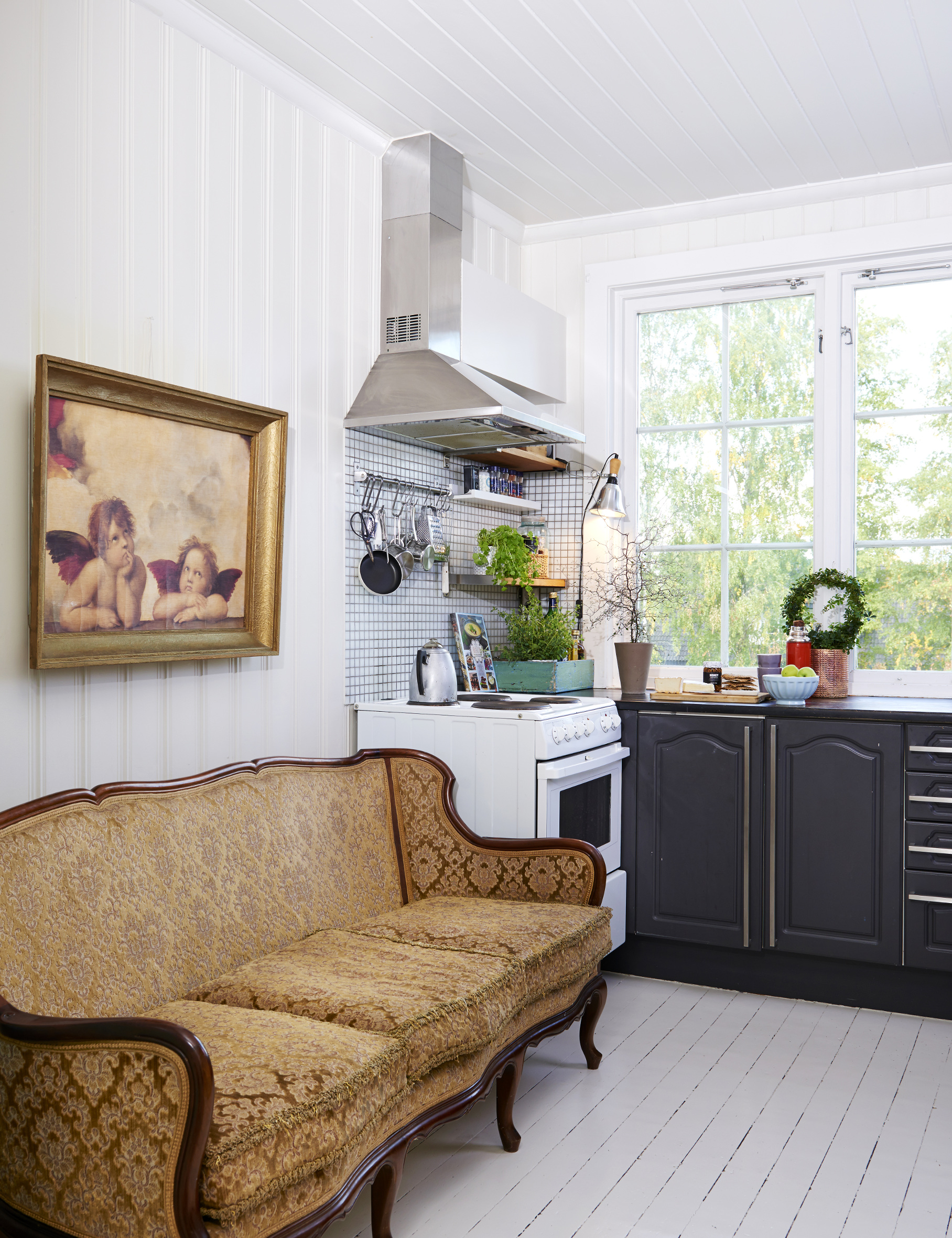NOSTALGI: Rommet er smalt, så her ble det prioritert hardt – sofaen vant over kjøkkenskap! Både bilde og sofa understreker stilen, godt samstemt med gamle vegg- og gulvbord, som for øvrig er malt i én farge. 