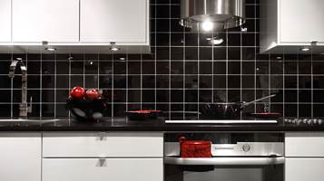 Sorte fliser med hvit fug i kontrast gir et tøffere utseende til kjøkkenet. Fra Golvabia.