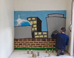  INKOGNITO:  En ung grafittikunster fikk i oppdrag å dekorere endeveggen i Urban Café.