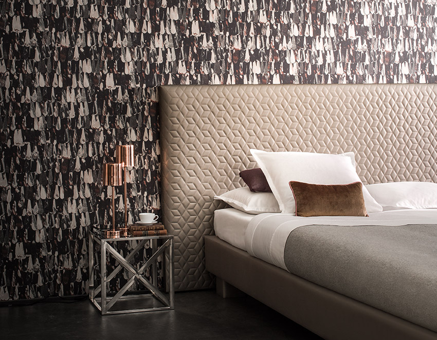 Nøytrale farger trenger ikke å være kjedelig. Bruk mørke, nøytrale farger for en mer dramatisk effekt. Lag-på-lag mønsteret på veggene bidrar til å skape spenning på soverommet.