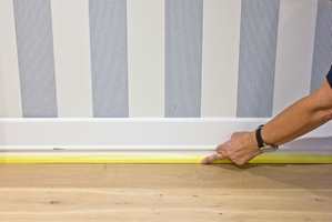 Press tapen godt inntil gulvlisten nederst mot gulvet, så unngår du at malingen trekker opp på listen.