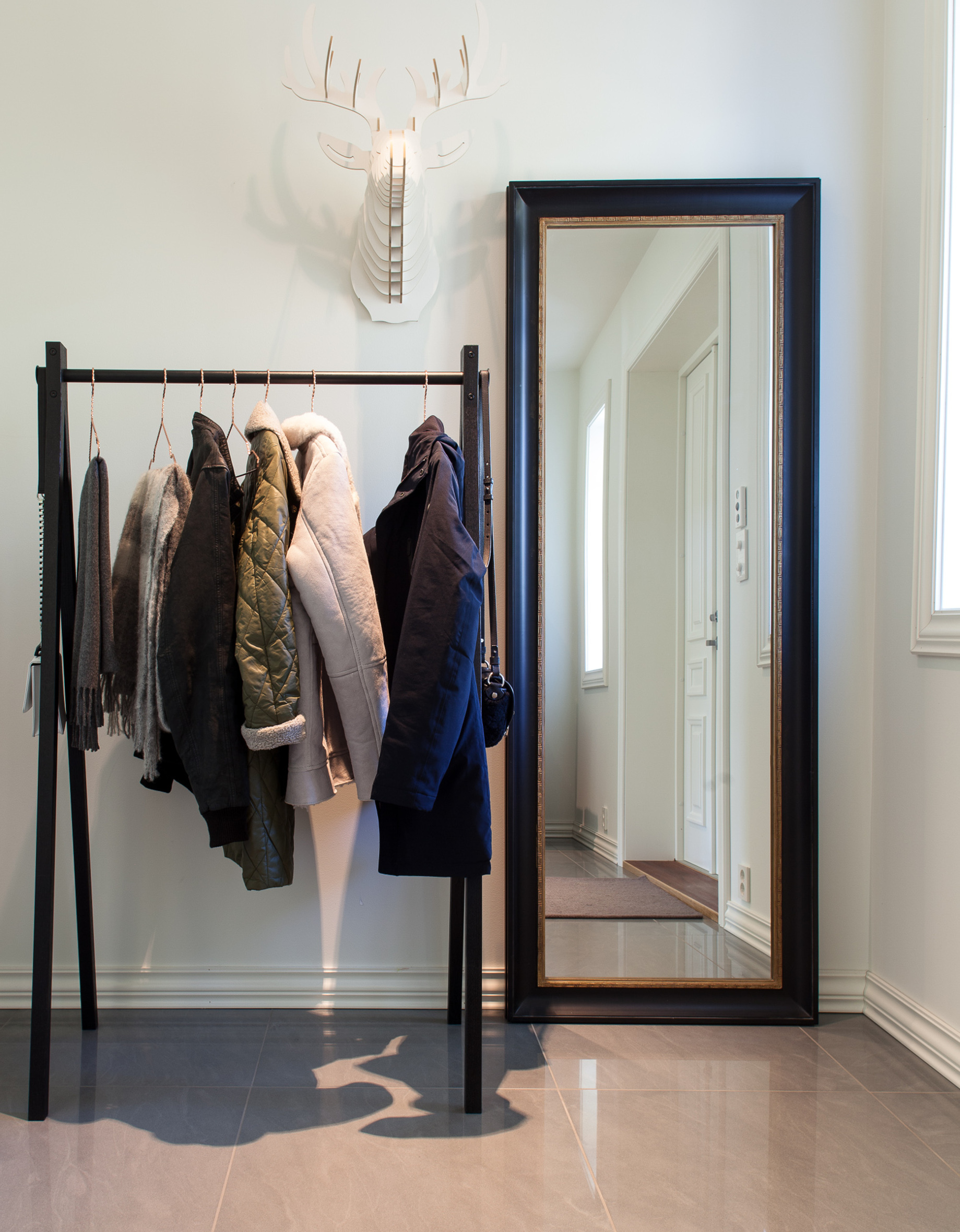 Klesstativ, speil og dyrehode danner et bilde. 