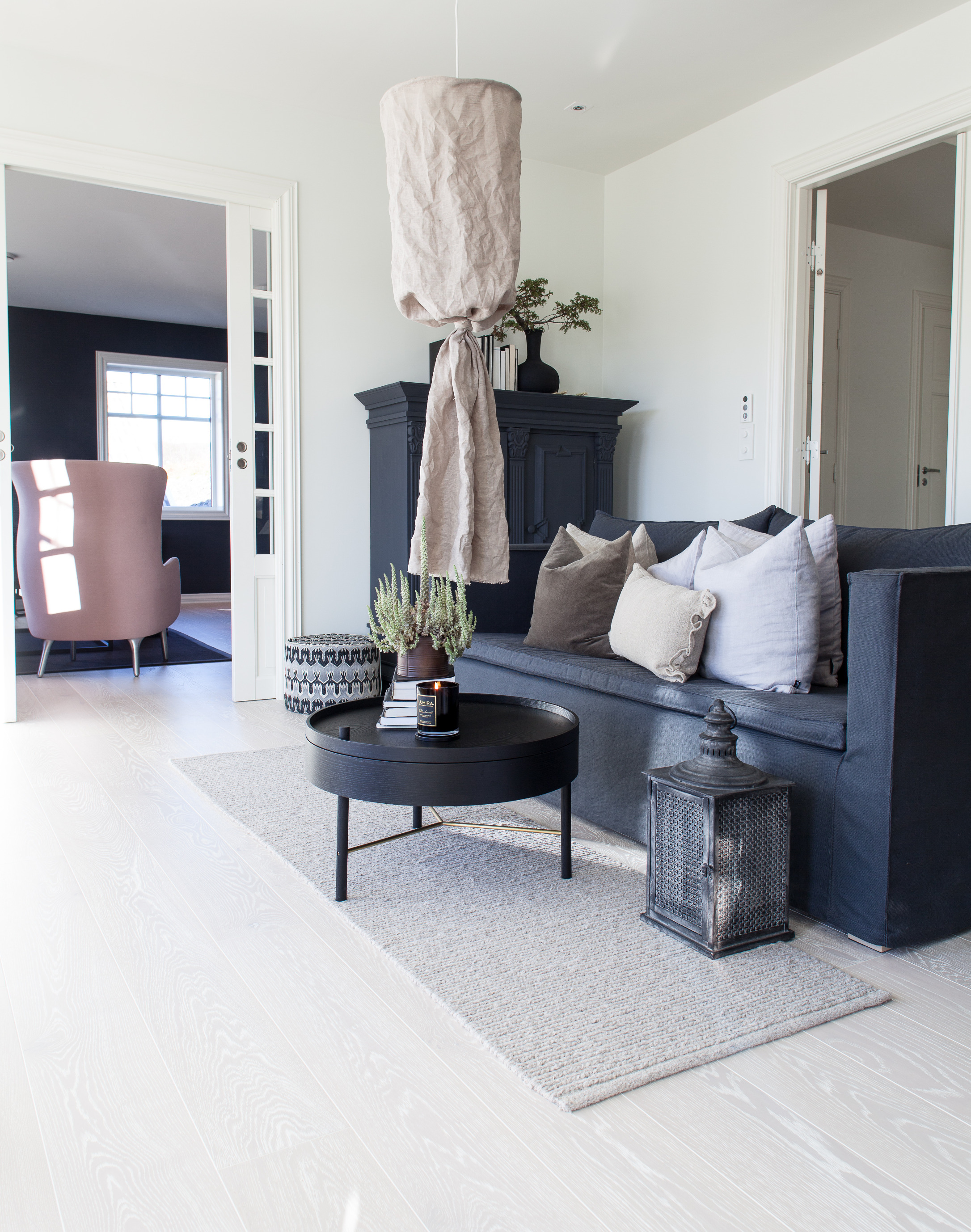 Lyse rammer med mørke elementer. I stuen innenfor er det motsatt – veggene er mørke. 