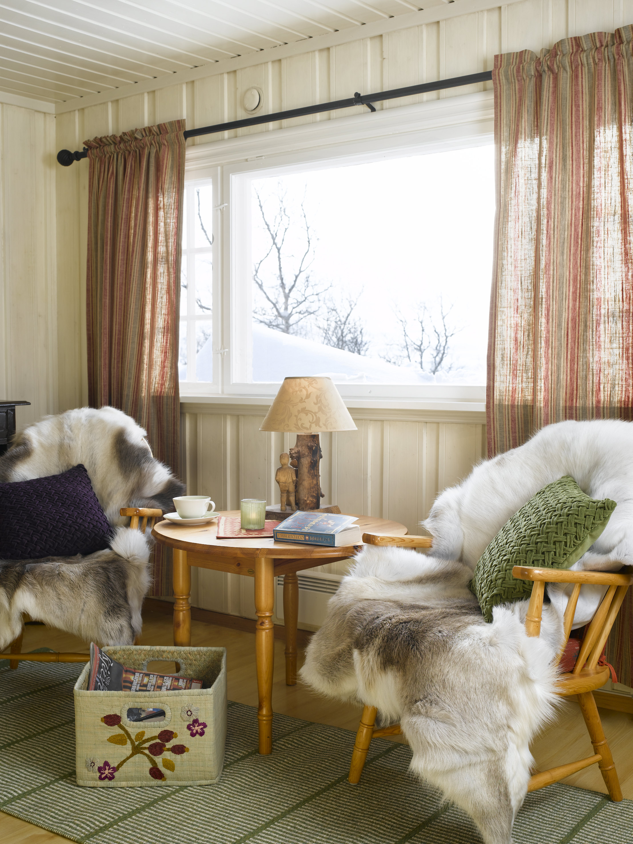 Gamle møbler mot nye farger. Her finner vi igjen grønnfargen fra dørene i gardiner og pute. 