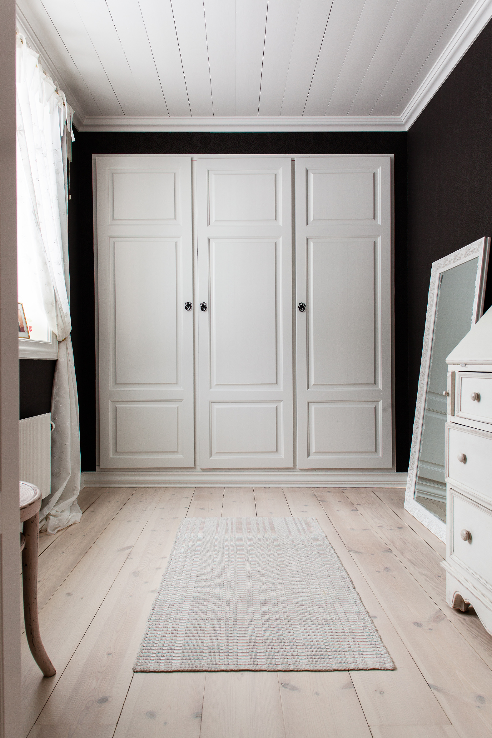 Den tilstøtende garderoben har samme tapet som soverommet, i en mørkere utgave. 